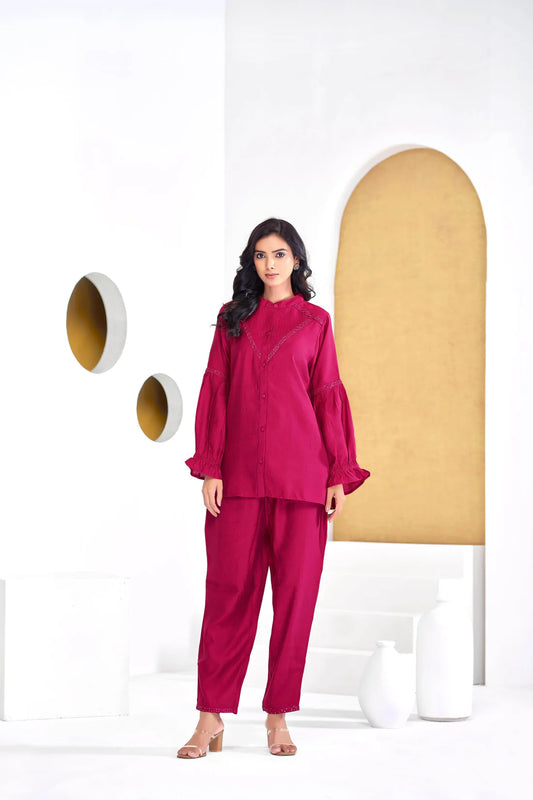 Woman wearing a pink outfit standing in a modern interior setting.